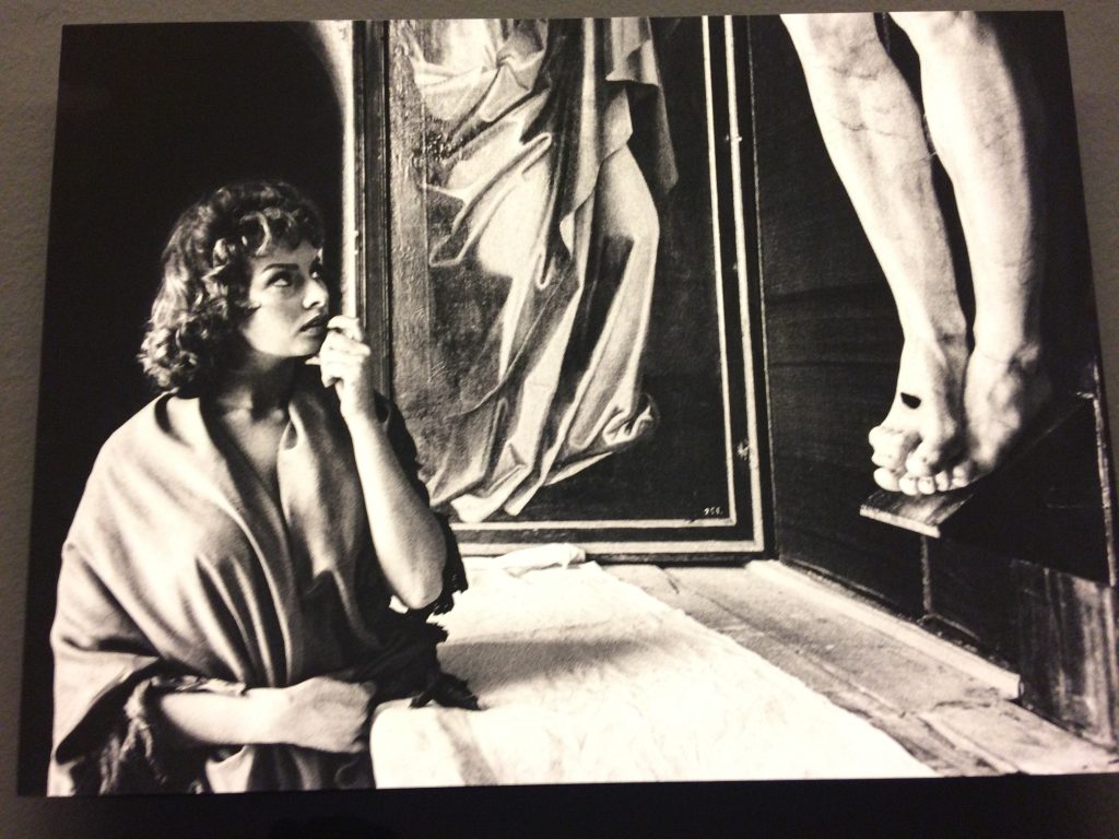 <em>Sophia Loren frente al crucifijo de Benvenuto Cellini durante el rodaje de ‘Orgullo y Pasion’ en el Monasterio de El Escorial. 1956. Getty Images. (Foto tomada en la exposición)</em>